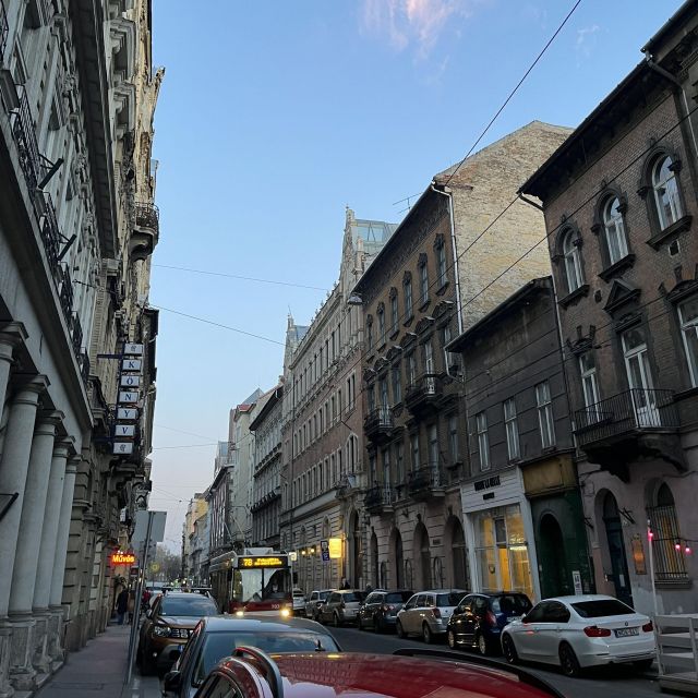 Straße in Budapest mit barocken Gebäuden links und rechts.