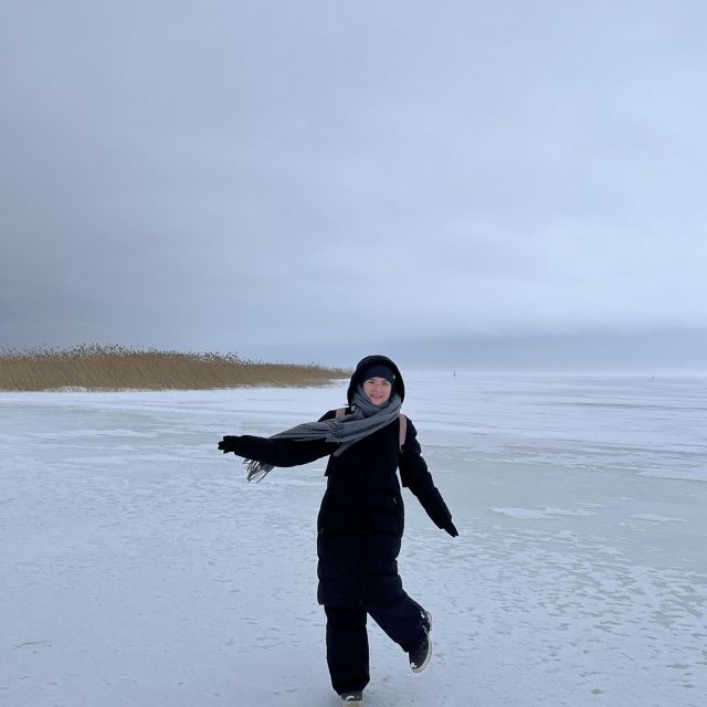 Frau steht auf einem zugefrorenen See in Winterkleidung