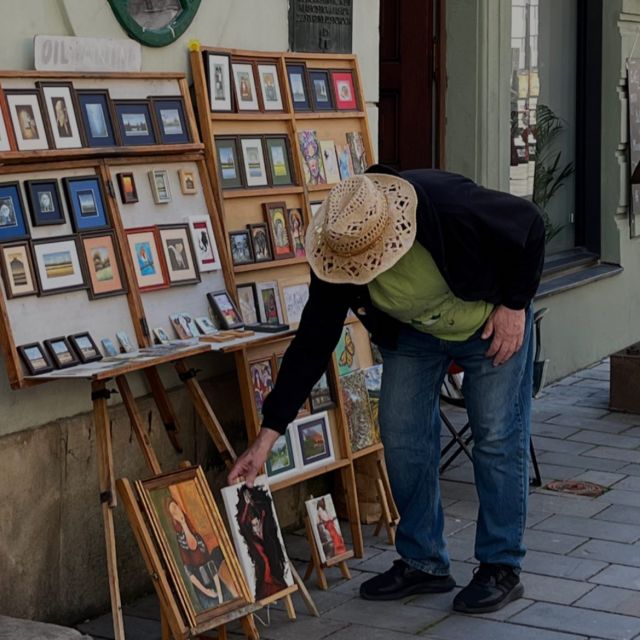 Ein Straßenmaler, der seine Kunstwerke am Straßenrand ausstellt