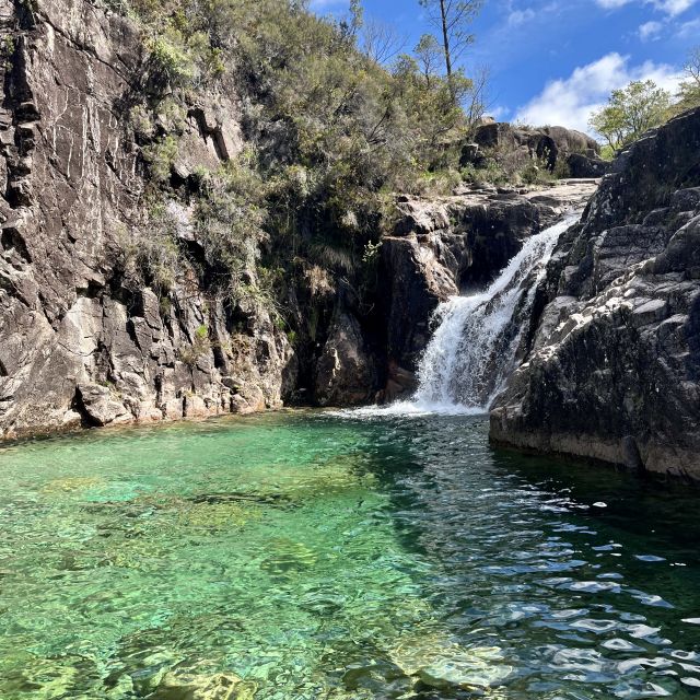 Ein Wasserfall mit einem blauen natürlichen Pool.