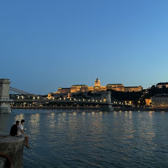 Am Donauufer bei Dämmerung. Im Hintergrund sieht man das leicht beleuchtete Buda Castle