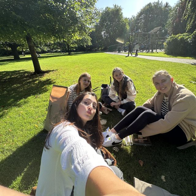 4 Mädchen sitzen bei Sonne im Park