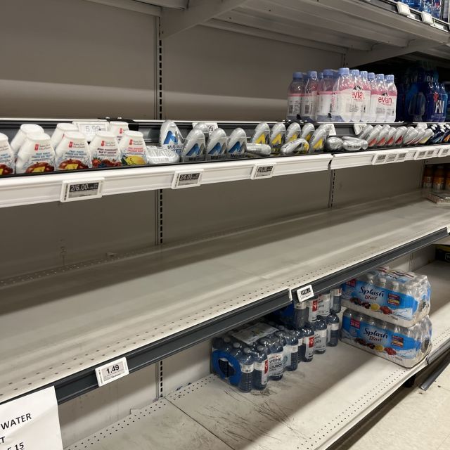 Regal im Supermarkt, in dem normalerweise Wasserflaschen zu kaufen sind. Es sieht sehr leer aus.