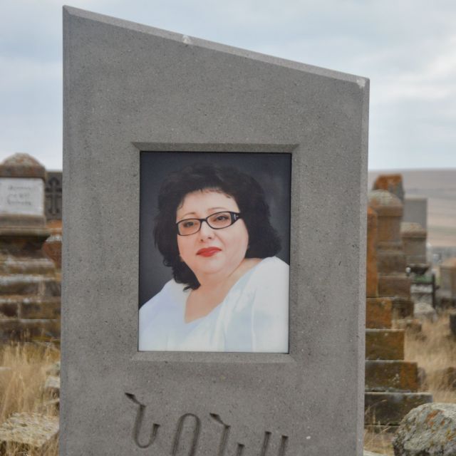 Das Portre einer Frau mittleren alters ist mit Farben auf ihren Grabstein zu sehen.