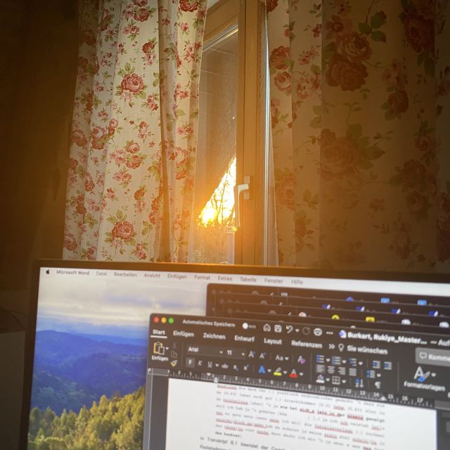 Im Vordergrund Desktop mit offenem Word-Dokument, im Hintergrund Fenster, durch das Licht (Sonnenuntergang) durchscheint.