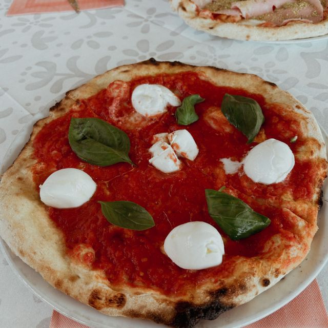 Pizza Buffala mit Tomatensoße, Büffelmozzarella und frischem Basilikum auf einem Tisch im Restaurant