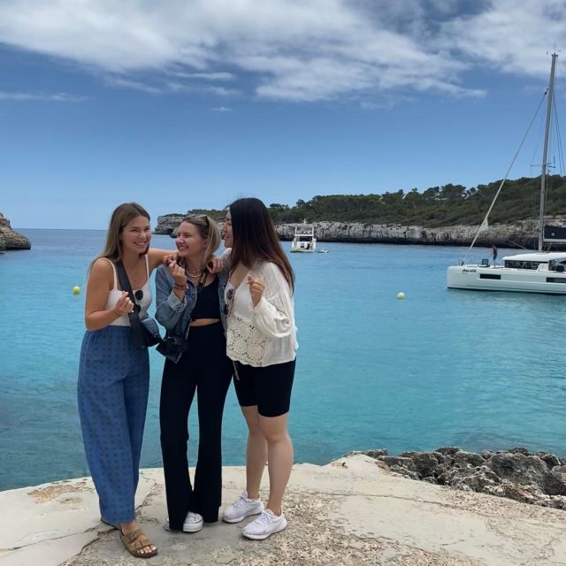 Susan und zwei Freundinnen lachen miteinander, im Hintergrund ist klares blaues Wasser zu sehen